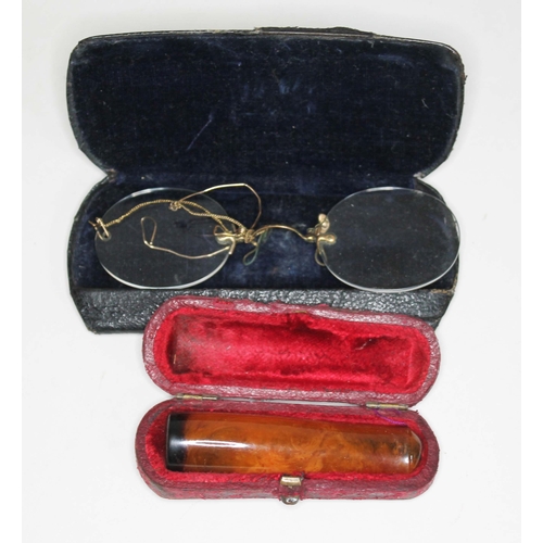 398 - A butterscotch amber cheroot holder and a pair of vintage spectacles.