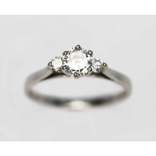 121 - A three stone diamond ring, the central six claw set round brilliant cut diamond weighing approx. 0.... 