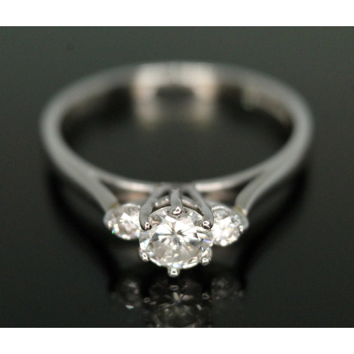 121 - A three stone diamond ring, the central six claw set round brilliant cut diamond weighing approx. 0.... 