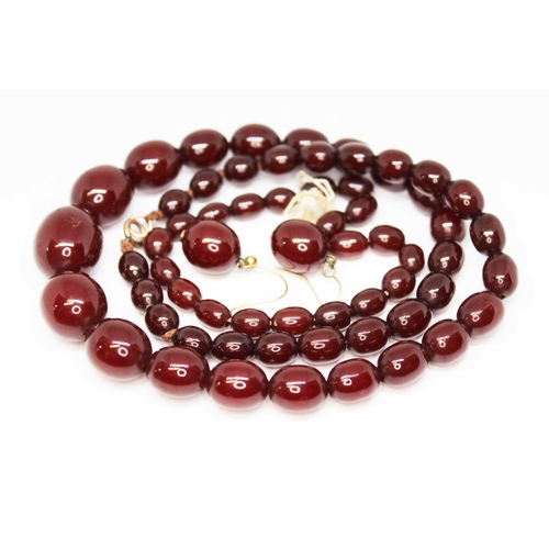 136 - A graduated slightly marbled cherry bakelite bead necklace, bracelet and earrings, beads ranging in ... 