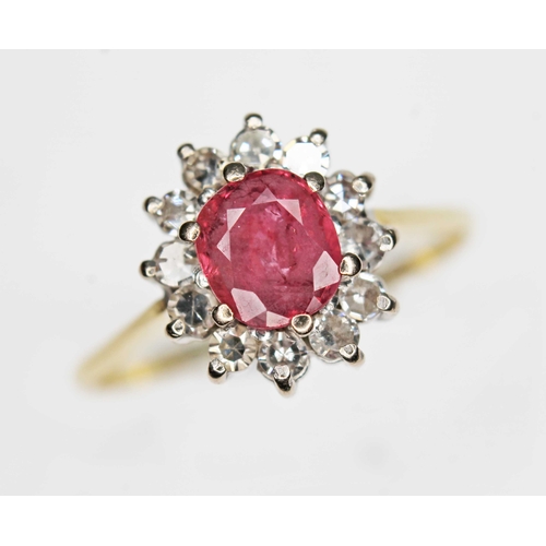 163 - A ruby and diamond cluster ring, the oval cushion cut ruby weighing approx. 0.79ct, surround by twel... 