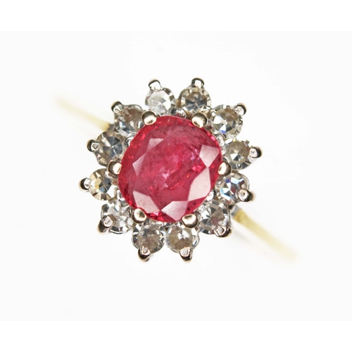 163 - A ruby and diamond cluster ring, the oval cushion cut ruby weighing approx. 0.79ct, surround by twel... 