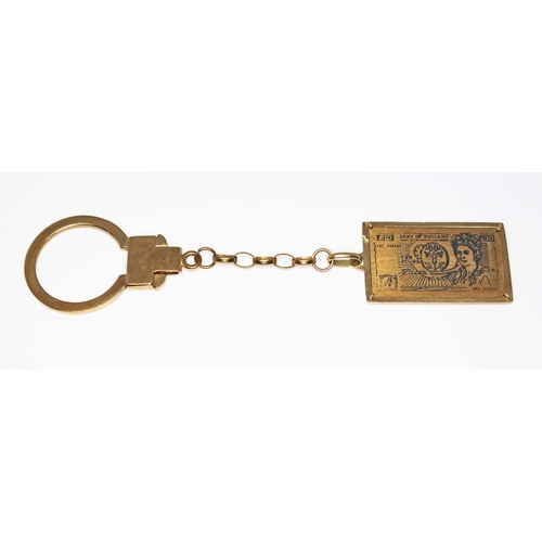 204 - A key fob, the drop modelled as a ten pound note, 9ct gold import marks, length 10cm, wt. 6.9g.