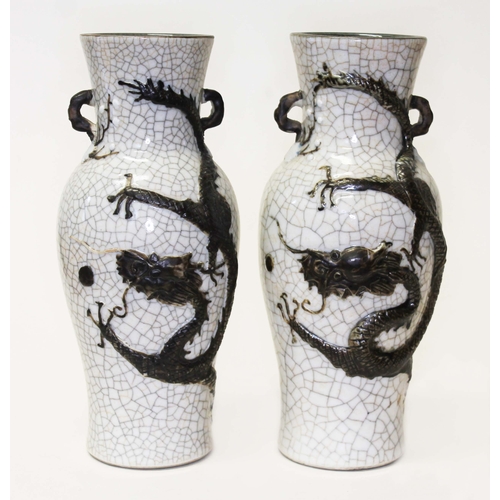 262 - A pair of Chinese crackle glaze vases with applied dragons, archaic marks to bases, height 25cm.