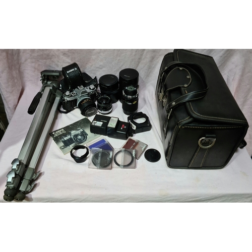 106 - A Canon AE-1 SLR camera with a wide angle lense, telescopic lense, case and a tripod.