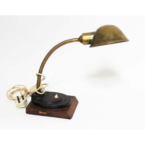 135 - An early 20th century brass angle lamp on stepped oval base and wooden plinth, max height 57cm.