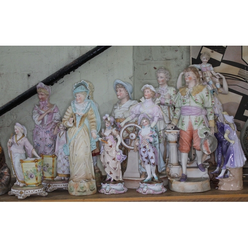 354 - A group of 14 porcelain figures comprising 12 bisque and another pair glazed, tallest 51cm.