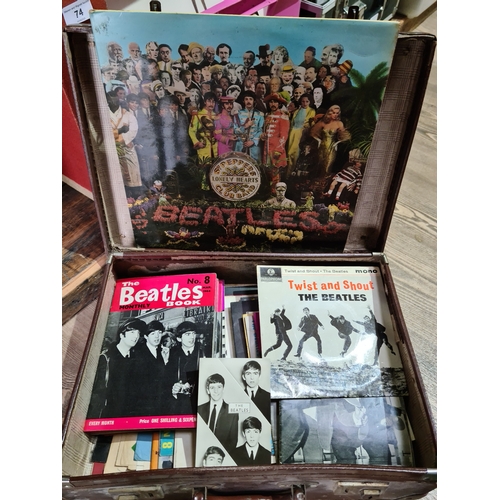 73 - A vintage leather case containing Beatles records, books and memorabilia.