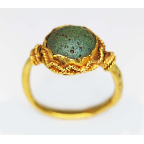 122 - An ancient ring, probably Western Asiatic, set with a green cabochon measuring approx. 11mm in diame... 