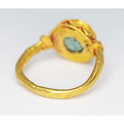 122 - An ancient ring, probably Western Asiatic, set with a green cabochon measuring approx. 11mm in diame... 