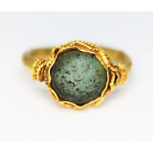 122 - An ancient ring, probably Western Asiatic, set with a green cabochon measuring approx. 11mm in diame... 