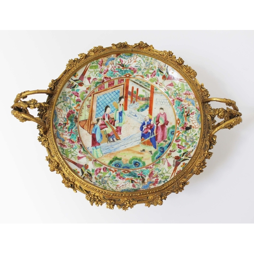 11 - A Chinese Canton dish, 19th century, decorated in over enamels with central panel depicting figures ... 