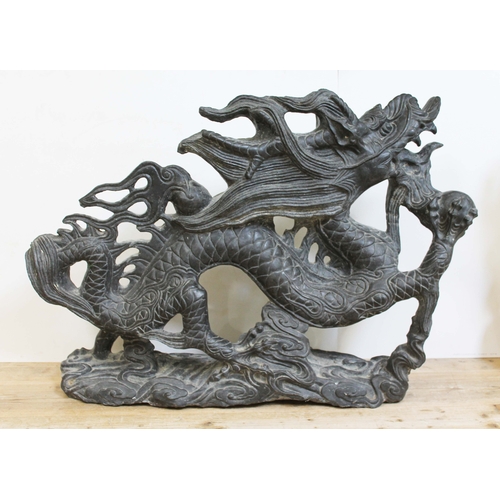 25 - A large Chinese black stone carving, modelled as a mythical dragon on a base of clouds, 20th century... 