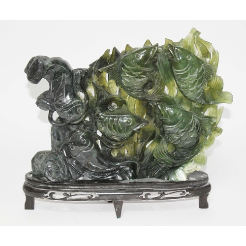 27 - A Chinese jadeite jade carving depicting four carp and two cat fish with seaweed background, on wood... 