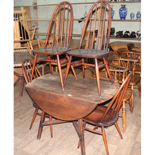 47 - An Ercol dark elm and beech drop leaf table and four chairs.