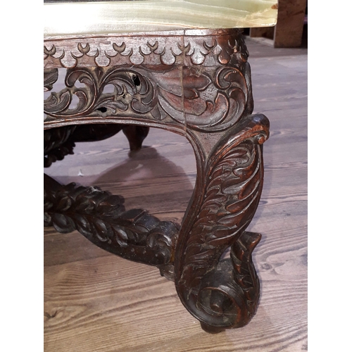 61 - A Chinese carved hardwood coffee table with onyx chess board top and resin pieces.