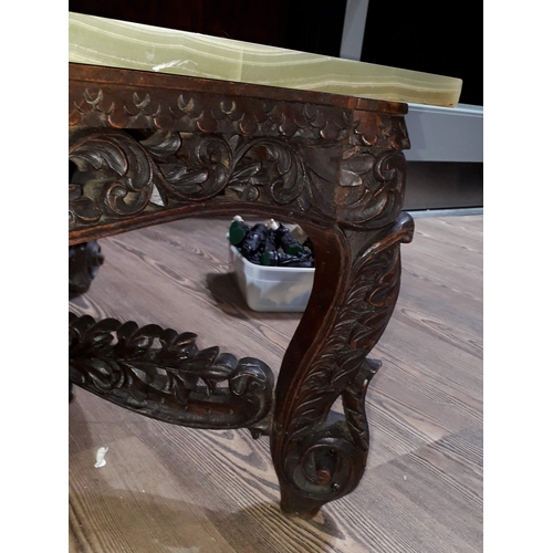 61 - A Chinese carved hardwood coffee table with onyx chess board top and resin pieces.