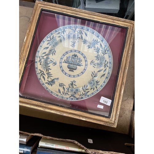 102 - A painted blue and white dish in a display cabinet