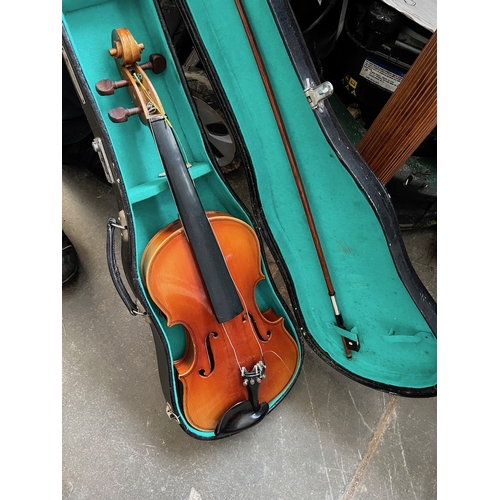 125 - A cased modern violin and a music stand