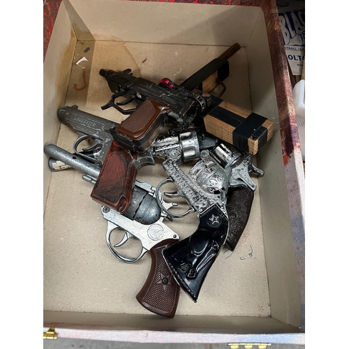 56 - A box of toy guns.