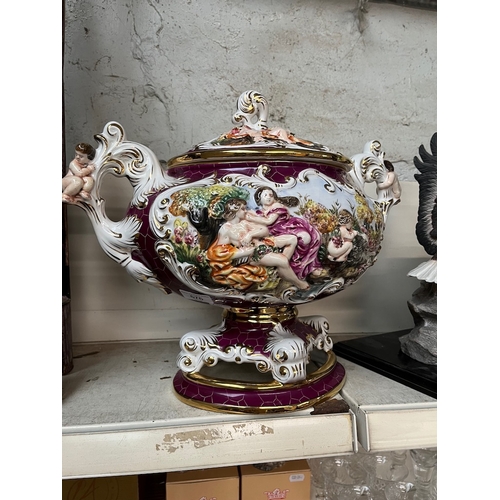 576 - A large Capodimonte tureen adorned with cherubs to handles, on an attached plinth, and with lid