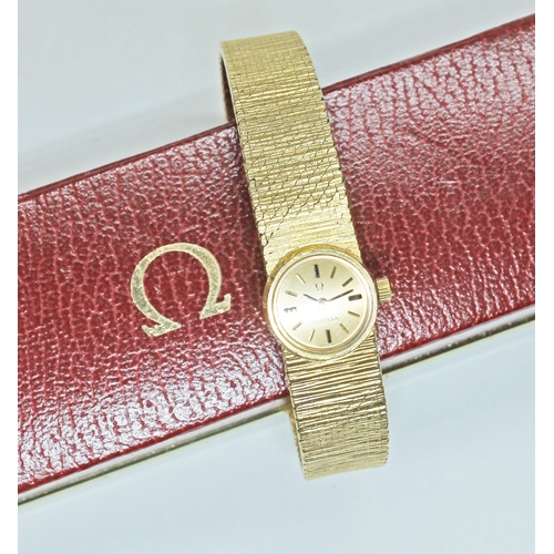 100 - A ladies 18ct gold Omega wristwatch, signed gold dial with gold and black baton hour markers, index ... 