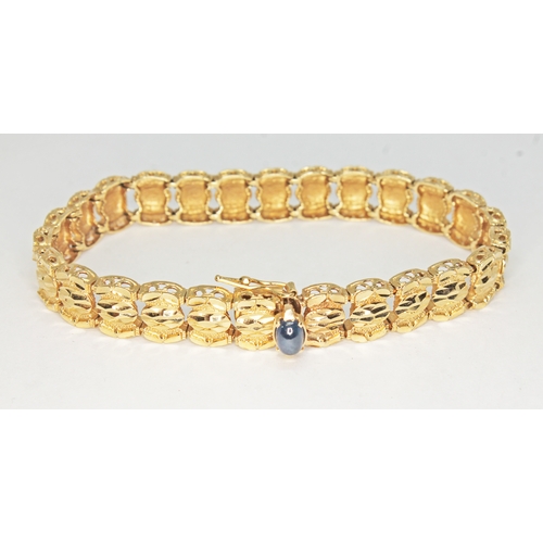 101 - A modern bracelet set with a sapphire cabochon, the flat bottom oval stone displaying slight chatoya... 