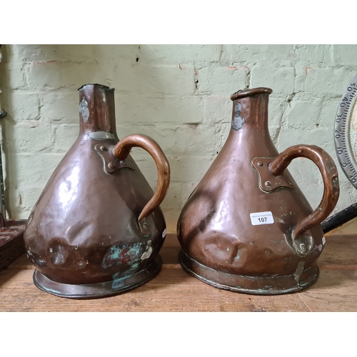 107 - A pair of copper jugs, stamped ER T47.