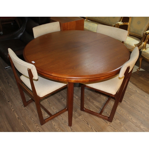 13 - A mid 20th century teak extending dining table and four chairs, diameter 122cm.