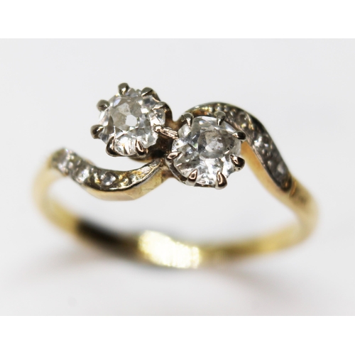 57 - A diamond crossover ring, the two old Eurpoean cut diamonds weighing approx. 0.30 carats each, colou... 