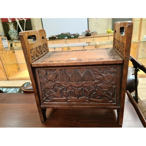 7 - An Art & Crafts carved oak box stool, height 56cm and width 51cm.