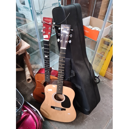 104 - Two accoustic guitars, a guitar case and two miniature guitars.