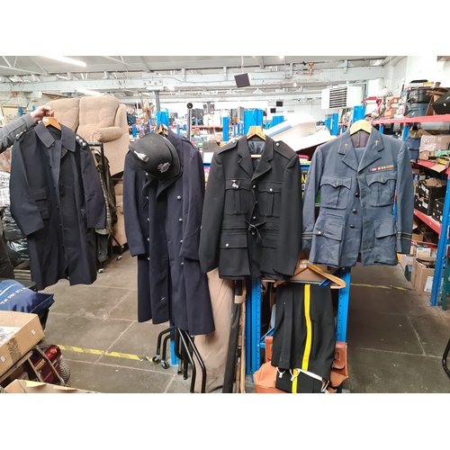 128 - Various military and constabulary clothing items to include trench coat, hat, uniforms, etc.