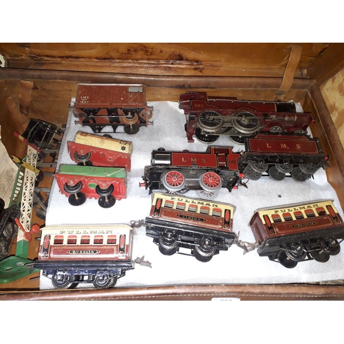 263 - A case containing Hornby 0 gauge clockwork railway comprising three engines, rolling stock and Railw... 