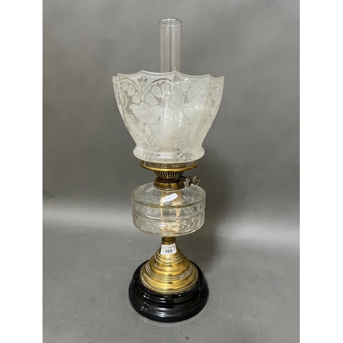 166 - A brass oil lamp with cut glass reservoir and etched glass shade.