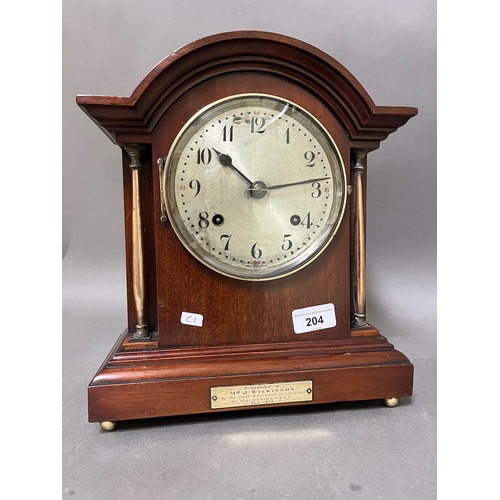 204 - A mahogany cased mantel clock with brass columns, on ball feet, with pendulum, no key.