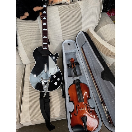 93 - A modern Gear4Music violin and a game's console guitar controller.