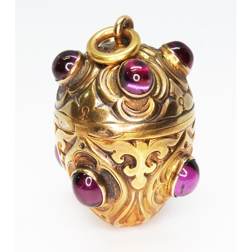 1 - A gilt metal vinaigrette, circa 1900, egg form and engraved, set with eight rhodolite garnet cabocho... 