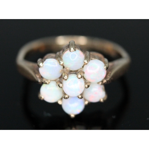 47 - A hallmarked 9ct gold opal cluster ring, the five opal cabochons arrange in a flower shap measuring ... 