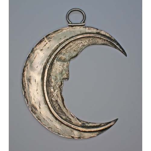 254 - An unusual white metal crescent moon pendant(?), possibly 19th century, length 11cm, wt. 43.5g.