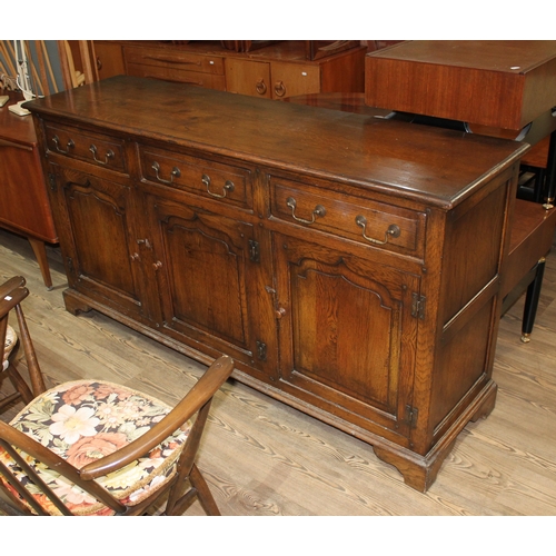 303 - A reproduction aged oak sideboard, length 169cm, depth 46cm & height 89cm.