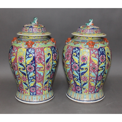 338 - A pair of Chinese Famille Rose porcelain vases, mid 19th century, of baluster form, covers with lion... 