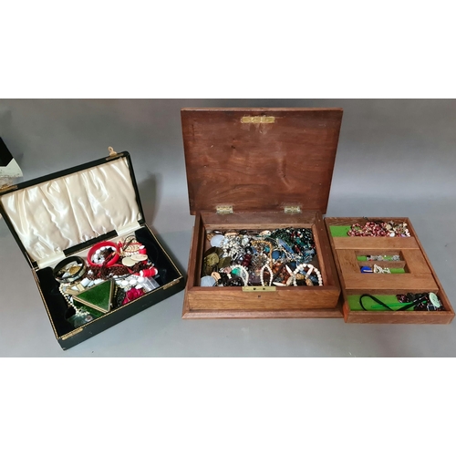 An antique carved wooden box containing costume jewellery and a vintage