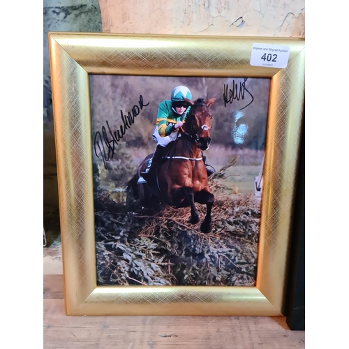 402 - A framed 2021 Grand National winner photograph signed by jockey and trainer.