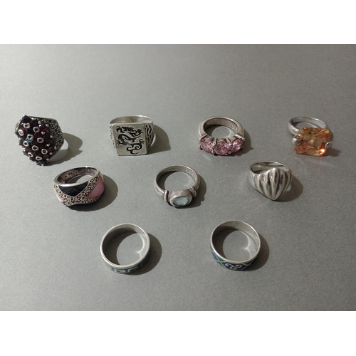 62 - Nine assorted silver rings, various settings.