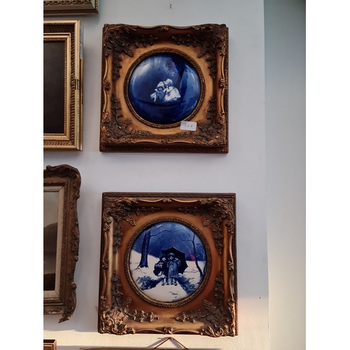 868 - A pair of circular blue and white Delft ceramic plaques, diameter 17.5cm, gilt frames.