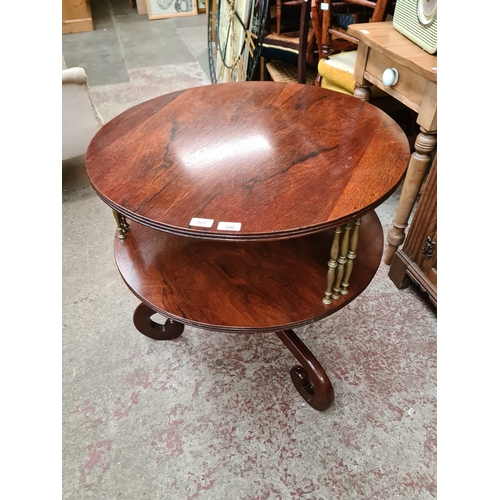 901 - A Regency rosewood two tier dumb waiter with brass columns, standing on scroll legs, diameter 71cm &... 