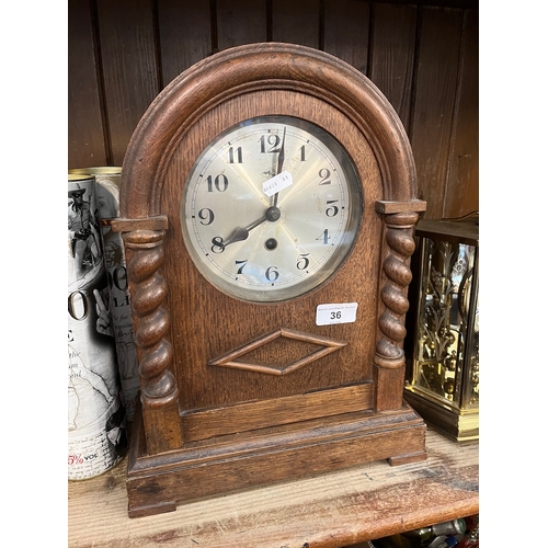 36 - An early 20th century oak cased German 8 day mantel clock with pendulum, key and barley twist column... 