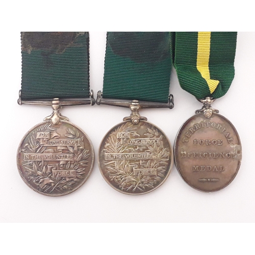 82 - A group of three medals comprising an unnamed Queen Victoria Volunteer Long Service medal, an Edward... 