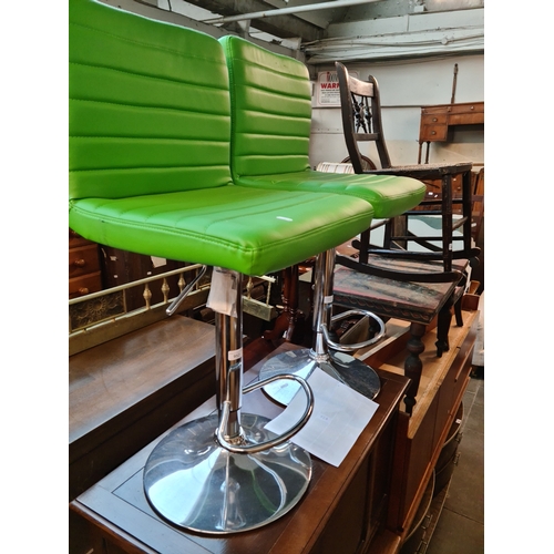 952 - A pair of chrome and green faux leather kitchen/ bar stools.